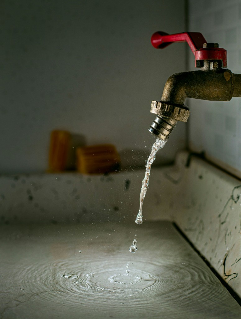Brass tap with water running into a basin